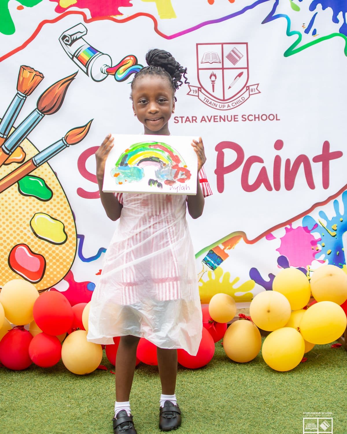 A pupil with her painting at the backdrop