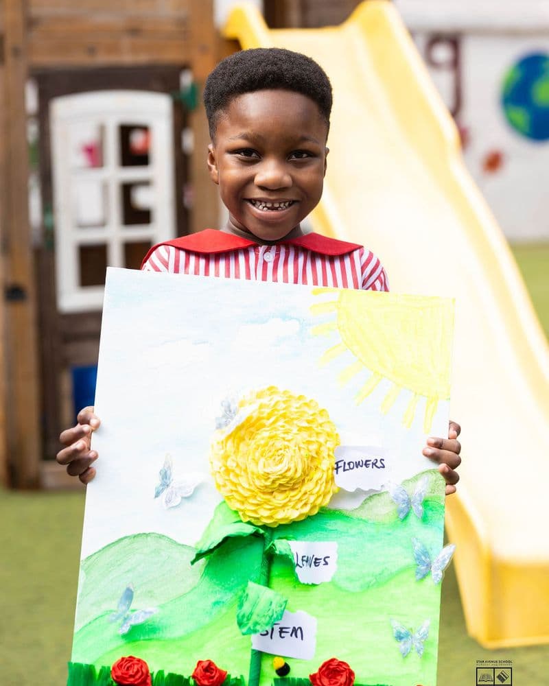 A pupil holding up a hand-made sunflower project