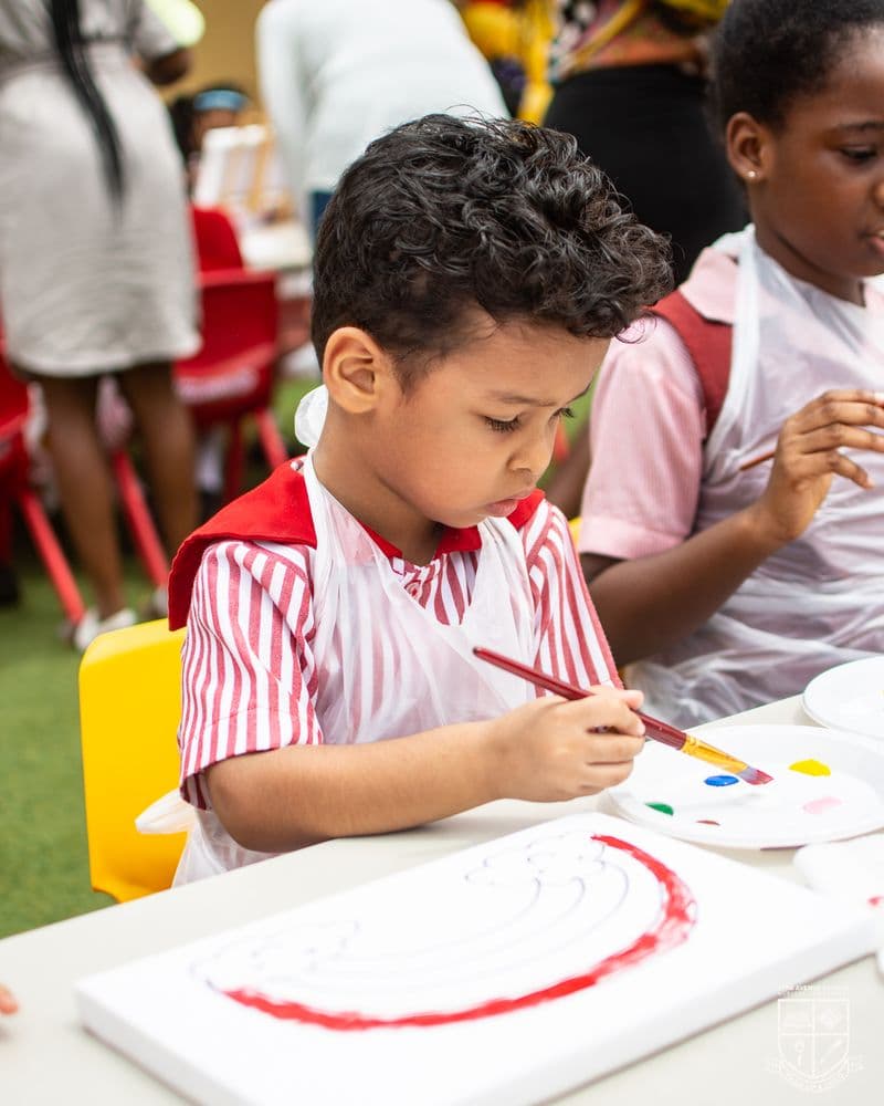 A preschooler concentrating on a painting at the table