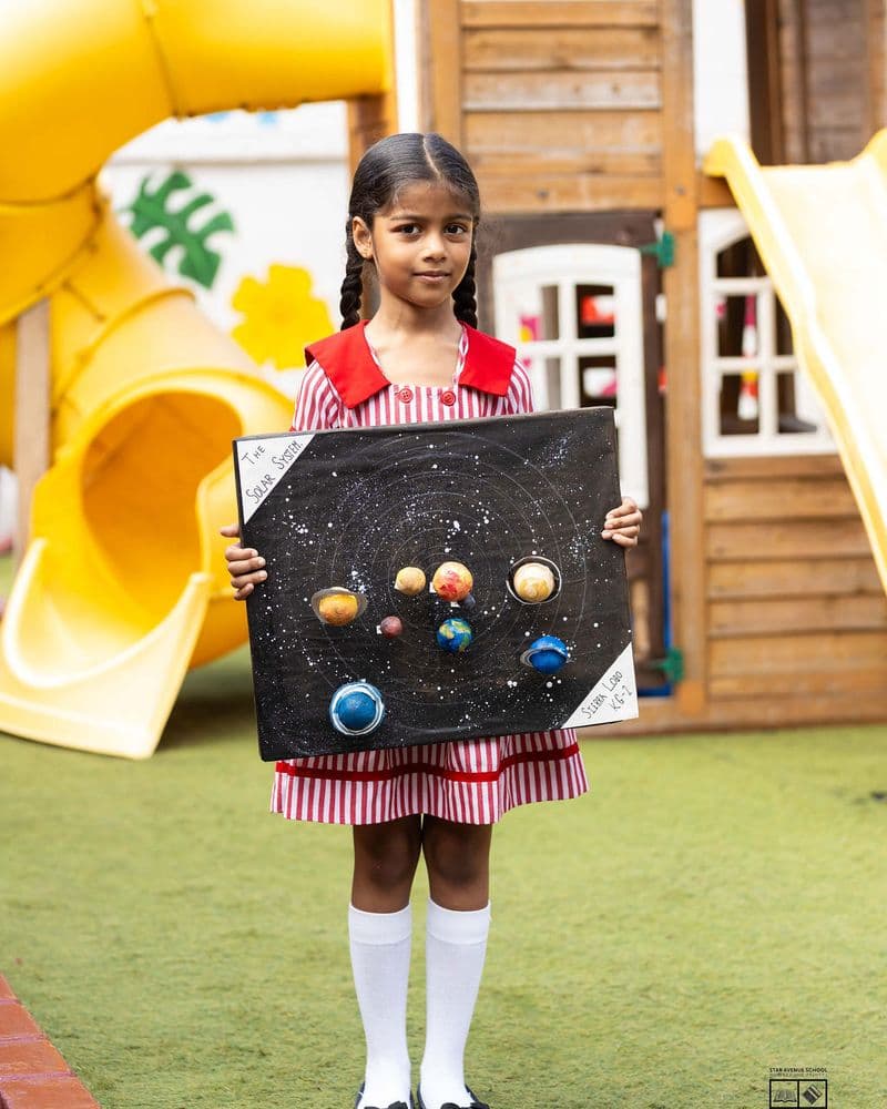 A pupil presenting a solar system board they made