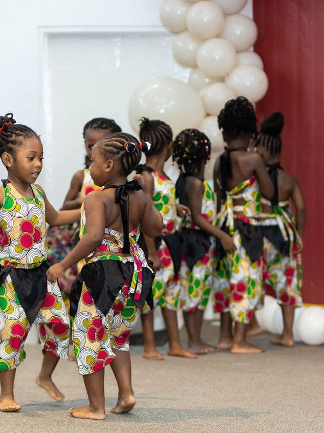 Pupils in Ghanaian dress on stage for a cultural performance